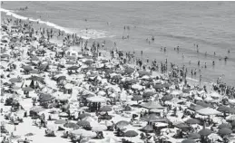  ?? AMANDA RIPPEN WHITE/AP ?? People crowd the beach in Ocean City in 2012. Millions of tourists are expected to visit the Atlantic Ocean resort this summer, but attracting enough seasonal workers to meet their needs has become a challenge for businesses.