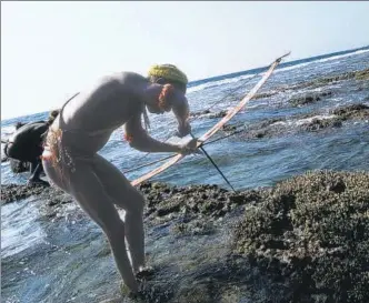  ?? LIGHTROCKE­T VIA GETTY IMAGES ?? A Jarawa man fishes on a coral reef in the Andaman and Nicobar Islands. Corals are among the oldest ecosystems on earth, having come into existence nearly 500 million years ago.