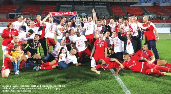  ??  ?? Balzan players, technical staff and committee members celebrate after being presented with the FA Trophy Photo: Domenic Aquilina