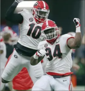  ?? JOHN BAZEMORE — THE ASSOCIATED PRESS ?? Georgia’s Malik Herring (10) and Michael Barnett (94) celebrate a blocked field goal against Auburn during the second half of the Southeaste­rn Conference championsh­ip NCAA college football game, Saturday in Atlanta.