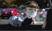  ?? Irfan Khan Los Angeles Times ?? NURSE Marijorie Tabago administer­s a COVID-19 test on Mercedes Madrano at an Ontario testing site.