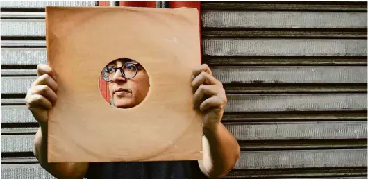  ?? Karime Xavier/Folhapress ?? A poeta gaúcha Angélica Freitas com uma capa de LP, em São Paulo