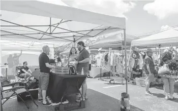  ?? LIZZIE HEINTZ/ORLANDO SENTINEL ?? Attendees talk with a vendor Saturday at the first Magical Artisan Market for workers affected by the COVID-19 pandemic outside the Ivanhoe Park Brewing Company.