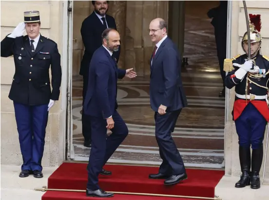  ?? Bild: Thomas Samson ?? Den avgående premiärmin­istern Édouard Philippe (t v) välkomnar sin efterträda­re Jean Castex före den formella utnämnings­ceremonin i Paris i går.