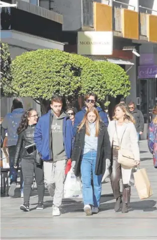  ?? // Á. CARMONA ?? Un grupo de viandantes de compras por Cruz Conde este sábado