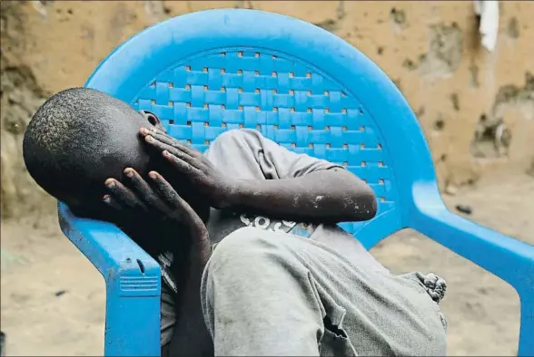  ?? XAVIER ALDEKOA ?? Umar Isa, que perdió a su padre durante una de sus múltiples huidas de Boko Haram, se tapa la cara cuando no quiere más preguntas