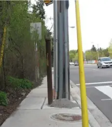  ?? JACK LAKEY ?? A utility pole and adjacent metal pipe take up at least half the sidewalk on the west side of Bayview Ave., near Post Rd., creating a tight squeeze.