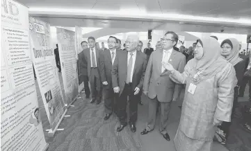  ?? — Photo by Chimon Upon ?? Yasmin (right) briefly goes through what is displayed along the way to the conference hall. Seen from second right are Abang Johari and Manyin. Fatimah is behind Yasmin.