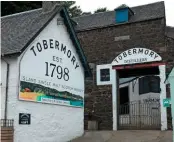  ??  ?? The tapering granite Clock Tower, with its roof on top, by Tobermory harbour (left). The distillery at Tobermory produces two distinct single malts, one non-peated and the other heavily peated, as well as gin (right).