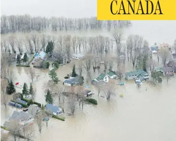  ?? PAUL CHIASSON / THE CANADIAN PRESS ?? Water spills over to homes in Rigaud, Que., on Monday in what the provincial government is calling historic flooding.