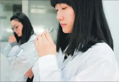  ?? PROVIDED TO CHINA DAILY ?? Two odor assessors work in the laboratory at Chongqing Jiangbei Environmen­t Monitoring Station.
