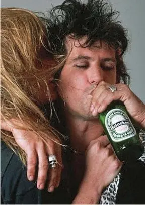  ??  ?? High life: Richards embraces Patti Hansen… and a beer, in 1981