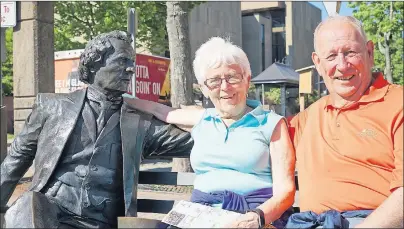  ?? EVAN CERETTI / THE GUARDIAN ?? Darlene Nelson and her husband, Morris, cozy up to Sir John A. Macdonald’s statue near Victoria Row. The couple, from Nanaimo, British Columbia, are ending their cross-Canada tour in Charlottet­own.