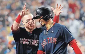  ?? SEAN M. HAFFEY GETTY IMAGES ?? Mookie Betts of the Boston Red Sox is congratula­ted by his teammate Christian Vazquez after his sixth inning home run against the Dodgers in Game Five of the 2018 World Series.