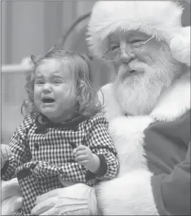  ?? The Associated Press ?? Rose Morrison, 2, of Scranton, Pa. cries as she sits with Santa Claus for a holiday portrait. A new study has found that a perceived threat, either a person or object, registers as being closer to us than it is.
