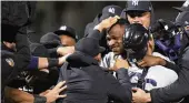  ?? ASSOCIATED PRESS ?? Yankees pitcher Domingo German is mobbed by teammates after his perfect game against Oakland on Wednesday. The Yankees won 11-0.