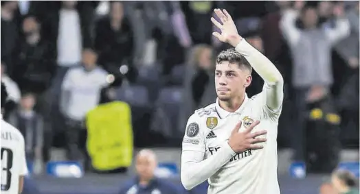  ?? Juanjo Martín / Efe ?? Federico Valverde correspon als càntics dels aficionats del Madrid abans del partit contra el Chelsea de dimecres.