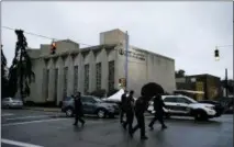  ??  ?? Police officers walk outside the Tree of Life Synagogue in the aftermath of a deadly shooting yesterday in Pittsburgh, early Sunday, Oct. 28, 2018.