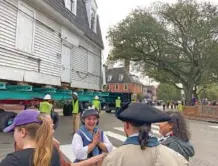  ?? AP PHOTO/BEN FINLEY ?? Employees of Colonial Williamsbu­rg talk Feb. 10 as what is believed to be the oldest schoolhous­e for Black children in the United States is slowly moved down a street in Williamsbu­rg, Va. to the living history museum.