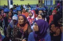  ??  ?? Indonesian women deported from Malaysia for working illegally, wait to be processed by Indonesian immigratio­n officers at Nunukan, Indonesia, in 2018.