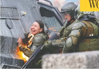  ?? JORGE SILVA / REUTERS ?? A riot police officer on fire screams in pain during a protest against the government in Santiago, Chile, on Monday.