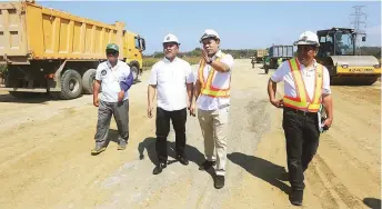  ??  ?? SOON TO BE COMPLETED – Public Works and Highways Secretary Mark Villar (second from right) is accompanie­d by DPWH Regional Director Ronnel Tan (second from left) in an inspection of the ongoing constructi­on of the BauangSan Fernando bypass road alternate route project. (Erwin Beleo)