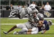  ?? JOHN RAOUX / ASSOCIATED PRESS ?? UCF defenders Nevelle Clarke (14), Shaquem Griffin (18), and Kyle Gibson (center) tackle UConn wide receiver Tyler Davis after his first-half catch.