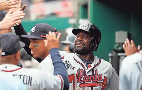  ?? Carolyn Kaster / The Associated Press ?? Atlanta’s Brandon Phillips celebrates in the dugout with teammates after scoring in the first inning of Wednesday’s game in Washington.