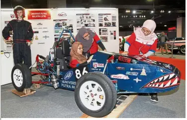  ??  ?? Revving up: (From left) UPM mechanical engineerin­g students Umaitul Afiqah, Siti Khairiah and Nur Fitriana demonstrat­ing the use of a single-seat race car they built at KLIMS’18 at Mitec.