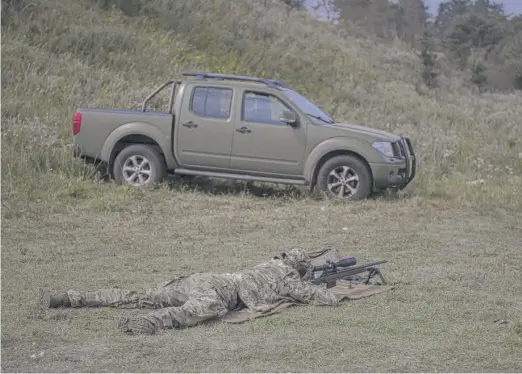  ?? ANDREW KRAVCHENKO/AP ?? Ukrainian sniper Andriy attends a training session on Aug. 27 outside of Kyiv, Ukraine. After moving to Western Europe to work as an engineer, Andriy scrambled back to Ukraine at the start of the war and within weeks underwent a conversion from civilian life to a sniper.