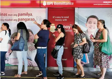  ??  ?? Promising market: Domestic helpers line up for remittance services in Hong Kong. South-East Asia, with a growing population of 600 million people who mostly lack bank accounts, is a strategic battlegrou­nd for Asian tech behemoths and their US rivals. — Reuters