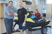  ??  ?? The lucky winner of the SEA-DOO, Mike Vandenberg­he of Moose Jaw with Ford Sales Associate, Greg Carline