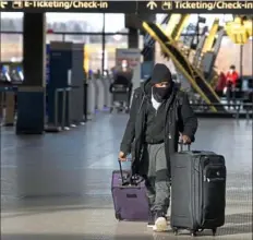  ?? Pittsburgh Post-Gazette ?? Fabian Neeley, originally from Youngstown, walks over to the ticket counter Wednesday at Pittsburgh Internatio­nal Airport in Findlay. Mr. Neeley is returning to Anchorage, Alaska, where he is stationed in the United States Army.