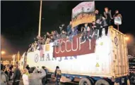  ?? PICTURE: AP ?? WATCH IT: Protesters sit on top of a container truck at the Port of Oakland, California. The “Occupy Wall Street” movement hoped the demos would send a message that their movement was not over.