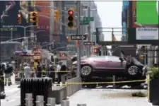  ?? MARY ALTAFFER - THE ASSOCIATED PRESS ?? In this Thursday photo, a car rests on a security barrier in New York’s Times Square after driving through a crowd of pedestrian­s, injuring at least a dozen people. A threefoot-tall piece of stainless steel in the ground ultimately stopped a speeding...