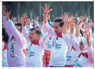  ?? — Reuters ?? Hands up: Joko and Vice-President Yusuf Kalla doing the poco-poco dance at the National Monument in Jakarta.