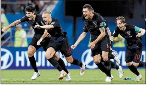  ?? AP/MANU FERNANDEZ ?? Croatian players rush forward to celebrate after Ivan Rakitic’s shootout goal secured the victory over Russia in the World Cup quarterfin­als Saturday in Sochi, Russia.