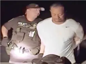  ??  ?? Under arrest: Woods is escorted by police officers in Florida