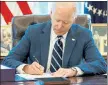  ?? MANDEL NGAN / GETTY IMAGES ?? President Biden signs the American Rescue Plan on Thursday in the Oval Office of the White House in Washington.