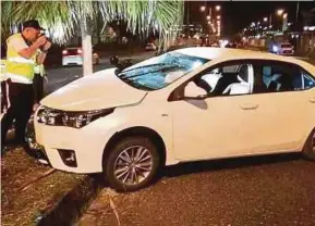  ?? [FOTO IHSAN PEMBACA] ?? Polis memeriksa kenderaan yang merempuh seorang peserta maraton dan marshal Annual Round The Island Relay di Jalan Sultan Azlan Shah, semalam.