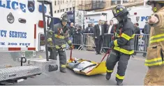  ?? MICHAEL GRAAE, GETTY IMAGES ?? During the active- shooter drill Sunday, New York City firefighte­rs drag an actor to safety on Kenmare Street.