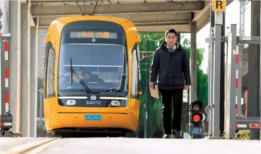  ?? ?? Xu Kailong, a tram driver, prepares for his shift during the day. — Ti Gong