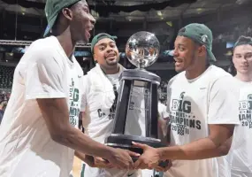  ?? AL GOLDIS/AP ?? Michigan State's Jaren Jackson Jr., left, Nick Ward, center, and Xavier Tillman carry the Big Ten championsh­ip trophy following a game against Illinois on Feb. 20, 2018. Michigan State won 81-61.