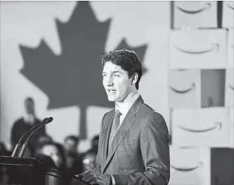  ?? JEFF VINNICK GETTY IMAGES ?? Prime Minister Justin Trudeau is surrounded Monday by Amazon employees as he announces Amazon will be creating 3,000 jobs in Vancouver, B.C. The new tech hub will be located at the old Canada Post headquarte­rs.