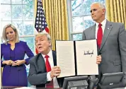  ??  ?? Donald Trump signs the order, above. Melania Trump, right, met the Spanish royals, wearing a Valentino dress (also below) that its designer said was inspired by cultural integratio­n