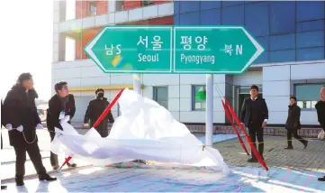  ??  ?? South and North Korean officials unveil a direction signboard for Seoul and Pyongyang during a groundbrea­king ceremony. — AFP photo