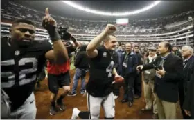  ?? EDUARDO VERDUGO — THE ASSOCIATED PRESS FILE ?? Raiders quarterbac­k Derek Carr, center, and defensive end Khalil Mack (52) leave the field after a game against the Texans in Mexico City. The Raiders return to Mexico City to face the Patriots this week.