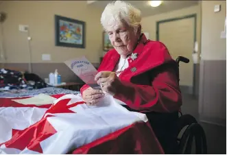  ?? LEAH HENNEL ?? Millie Smith, one of Confederat­ion Park’s founders, looks at some of the brochures at her home in Calgary she saved from the park’s 1967 dedication.