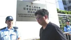  ??  ?? Yeung (centre) walks past a letter (back right) from the group displayed outside the China’s Liaison Office building in Hong Kong, after a Hong Kong journalist was arrested and left injured while trying to interview a human rights lawyer in Beijing. —...