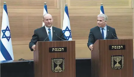  ?? MAYA ALLERUZZO AP ?? Israeli Prime Minister Naftali Bennett (left) speaks during a joint statement with Foreign Minister Yair Lapid at the Knesset in Jerusalem on Monday. Bennett’s office said his weakened coalition will be disbanded and the country will hold new elections.